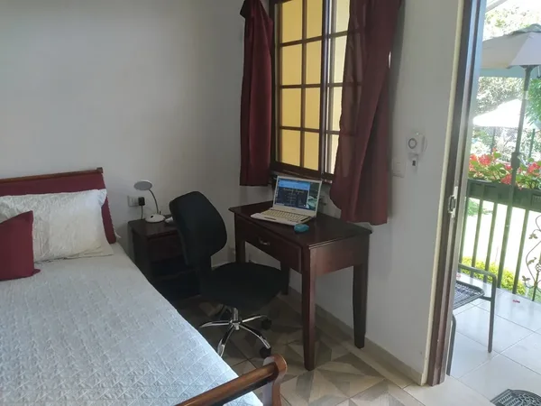 Bedroom with a desk and laptop next to the door to the terrace